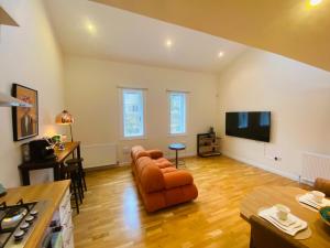 sala de estar con sofá y TV de pantalla plana en 2 Bed 2 bath with Private Parking, en Edimburgo