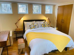 a bedroom with a bed with a yellow blanket and windows at 2 Bed 2 bath with Private Parking in Edinburgh