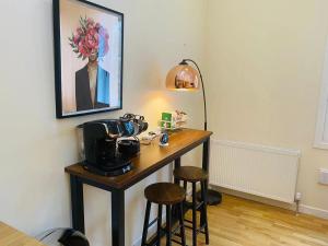 Zimmer mit einem Tisch mit Kamera und zwei Hockern in der Unterkunft 2 Bed 2 bath with Private Parking in Edinburgh