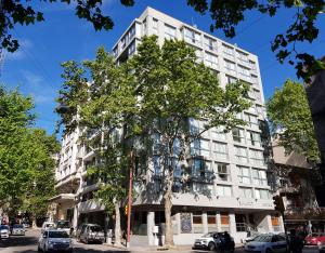 a tall white building with cars parked in front of it at Smart Hotel Montevideo in Montevideo