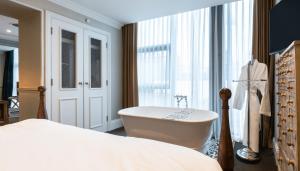 a bathroom with a bath tub, toilet and sink at King Street Townhouse in Manchester