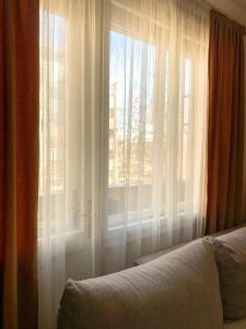 a bedroom with a window with white curtains at Cute, spacious apt in the heart of the old town in Podgorica