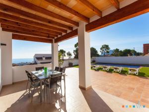un patio con mesa y sillas en la azotea en VH CostaBlanca - PINETS en Benissa