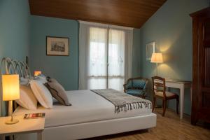 a bedroom with a bed and a desk and a window at Villa Barbara in San Giovanni in Marignano