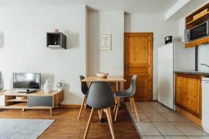 eine Küche mit einem Tisch und Stühlen sowie einem Kühlschrank in der Unterkunft Apartment with a furnished terrace close to the cable cars Rated 3 stars in Saint-Gervais-les-Bains