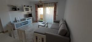 ein Wohnzimmer mit Sofa und Fernseher in der Unterkunft LyriosHomes Beach Costa Ballena in Chipiona