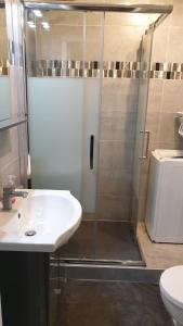 uma casa de banho com um chuveiro, um lavatório e um WC. em Les Cyclades em Le Lavandou