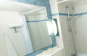 La salle de bains est pourvue d'une douche avec miroir et d'une baignoire. dans l'établissement Kyriad Châlons-En-Champagne - Saint-Martin, à Saint-Martin-sur-le-Pré