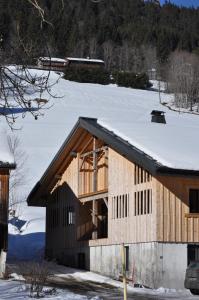 une maison en construction dans la neige dans l'établissement Appartement Chalet Louison, aux Gets