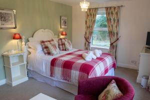 a bedroom with a bed and a chair and a window at The Old Vicarage in St Austell