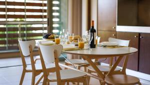 een eettafel met een fles wijn en stoelen bij Anchor Apartment - Herdade dos Salgados & Luxurious & 7 Pools & Golf in Albufeira