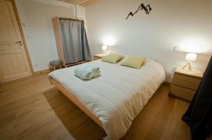 a bedroom with a large white bed with two lamps at Appartement Chalet Louison in Les Gets +16 photos