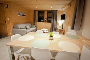 ein Esszimmer mit einem Tisch und weißen Stühlen in der Unterkunft Appartement Chalet Louison in Les Gets