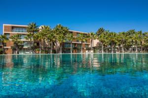 een zwembad met palmbomen voor een gebouw bij Anchor Apartment - Herdade dos Salgados & Luxurious & 7 Pools & Golf in Albufeira