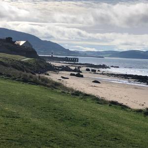 a beach with a building and the ocean and a house at Riverview Apartment in Buncrana
