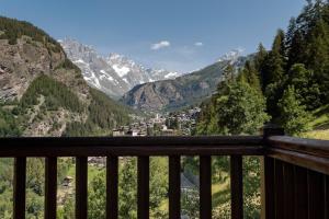 a view from a balcony of a valley with mountains at HelloChalet - Chalet da MiRo - Sunny terraces with stunning Matterhorn views, reachable on foot only in Valtournenche