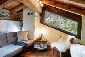 a living room with a couch and a window at HelloChalet - Chalet da MiRo - Sunny terraces with stunning Matterhorn views, reachable on foot only in Valtournenche