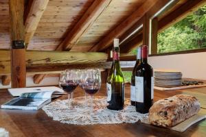 two bottles of wine and two glasses on a table at HelloChalet - Chalet da MiRo - Sunny terraces with stunning Matterhorn views, reachable on foot only in Valtournenche