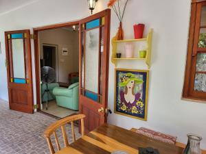 a dining room with a table and a chair and a door at Rosenhof Garden Cottage in Clanwilliam