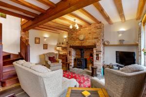 een woonkamer met banken en een open haard bij Shire Cottage in Broadway