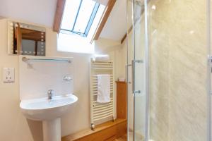 a bathroom with a sink and a shower at Shire Cottage in Broadway +14 photos
