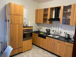een keuken met houten kasten en een koelkast bij NEXT TO MARK-51/7 Apartment - inkl. NETFLIX + PRIME - City-nah - Top Anbindung in Bochum