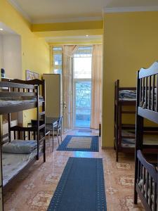 リヴィウにあるPANORAMI Apart Hostel in Lvivの二段ベッド、テーブル、窓が備わる客室です。