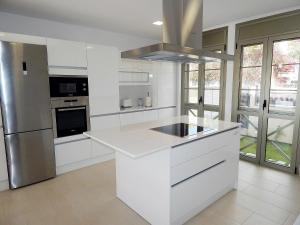 a kitchen with white cabinets and a stainless steel refrigerator at 5 bedrooms Villa Costa Adeje in Adeje