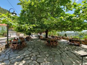 a group of tables and chairs under a tree at AETIA-TSIOURGIAKA in Aetia