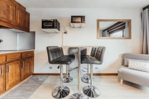 a kitchen with a table and two bar stools at Furnished studio on the ski slopes with a terrace & panoramic views in Saint-Gervais-les-Bains