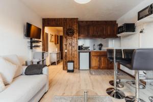 een woonkamer met een witte bank en een keuken bij Furnished studio on the ski slopes with a terrace & panoramic views in Saint-Gervais-les-Bains
