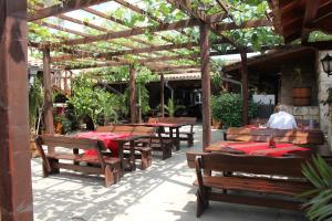 un groupe de tables et de bancs en bois dans un restaurant dans l'établissement Complex Dobrudja, à Kranevo