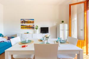 ein weißes Esszimmer mit einem weißen Tisch und Stühlen in der Unterkunft Appartamento Alba Rosa 5 - MyHo Casa in Alba Adriatica