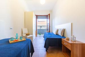 Zimmer mit 2 Betten, blauer Bettwäsche und einem Tisch in der Unterkunft Appartamento Alba Rosa 5 - MyHo Casa in Alba Adriatica