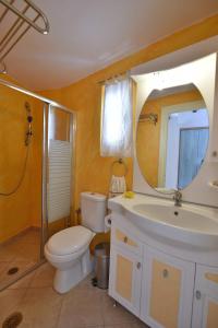 a bathroom with a toilet and a sink and a mirror at Freedom's house on Volaka Village Tinos in Vólax