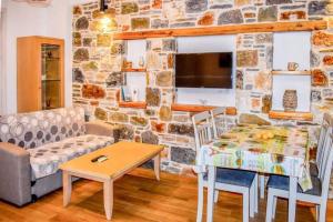 a living room with a table and a stone wall at Klaidis house in Skiathos