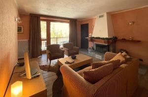 a living room with a couch and a fireplace at Suite - La Casa del Maestro in Pragelato