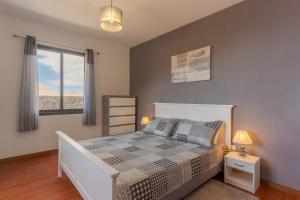 a bedroom with a bed with a view of the beach at Villa Rosa with private pool by HR Madeira in Ribeira Brava