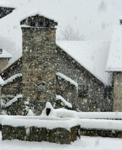 ein schneebedecktes Haus mit einem Stapel Schnee in der Unterkunft Antica Osteria Ghiridone in Palagnedra