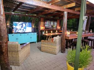 a patio with a table and a television in a pavilion at Rosenhof Garden Cottage in Clanwilliam