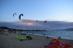 a group of people on the beach flying kites at Diamantis Kitesurf Villa in Mikri Vigla