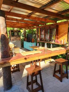 a wooden table on a patio under a wooden roof at Rosenhof Garden Cottage in Clanwilliam