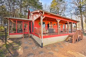 a red house with a porch and a deck at Serene Cabin with Riverfront Views and Access! in Fayetteville