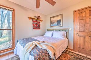 a bedroom with a bed and a window at Serene Cabin with Riverfront Views and Access! in Fayetteville