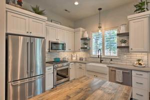 a kitchen with white cabinets and a stainless steel refrigerator at Modern Farmhouse with Patio, Grill and Mtn Views! in Ogden