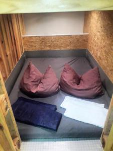 ein Bett mit zwei Kissen in einer Schachtel in der Unterkunft FOX BOX I Capsule Apt in Dresden
