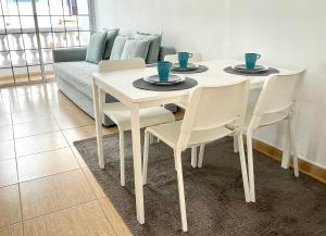 biały stół jadalny i krzesła z kanapą w obiekcie Sea Soul Apartment Puerto Santiago w mieście Puerto de Santiago