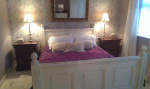 a white bed with two pillows and a mirror at The Retreat in Carlingford