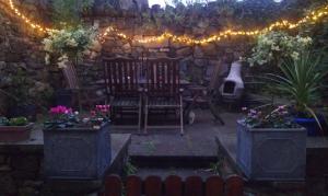 a patio with two chairs and a table with lights at The Retreat in Carlingford