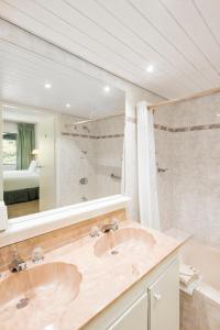 a bathroom with two sinks and a large mirror at Belair Beach Hotel in Philipsburg